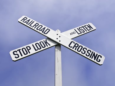 Railroad crossing sign with warning to stop, look, and listen